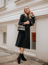 a lady in a black single-breasted crop jacket and black midi skirt
